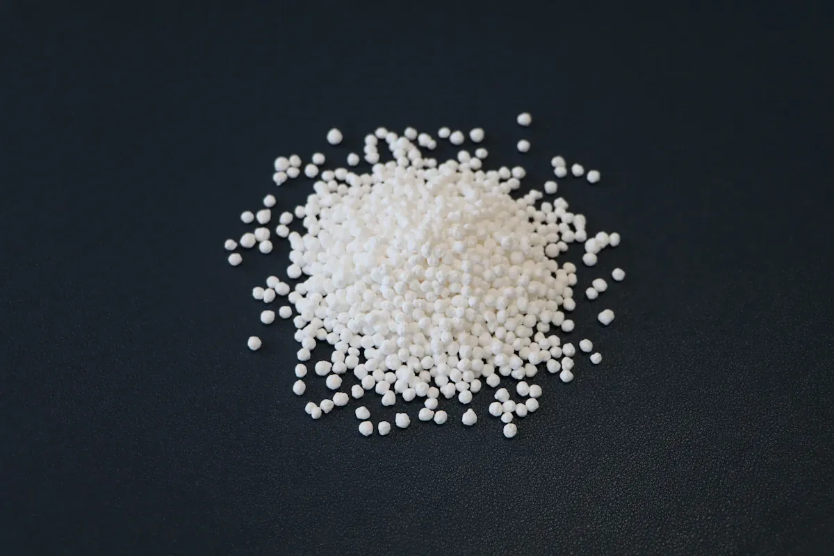 White granules of an industrial chemical on a dark surface